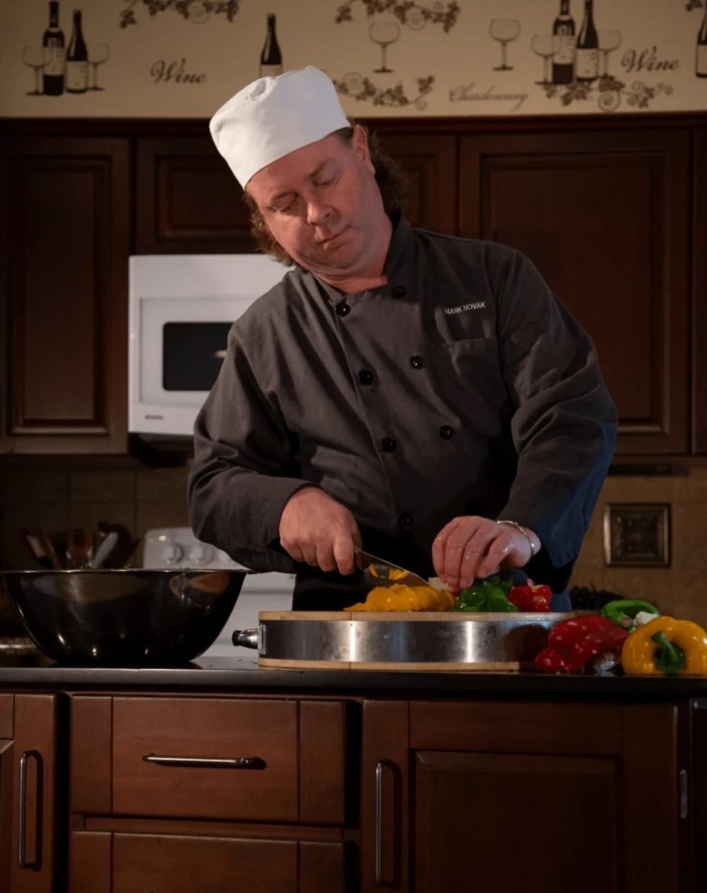 Mark Novak preparing fresh peppers in chef attire